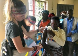 Sydney Roberts, left, at work at a rural community outreach health clinic outside of Kabale, Uganda where she helped conduct basic health screenings. Here she is measuring a woman’s MUAC (midupper arm circumference).