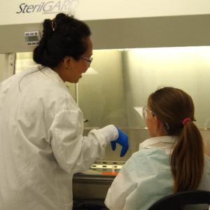 A Promega scientist works with a girl scout.