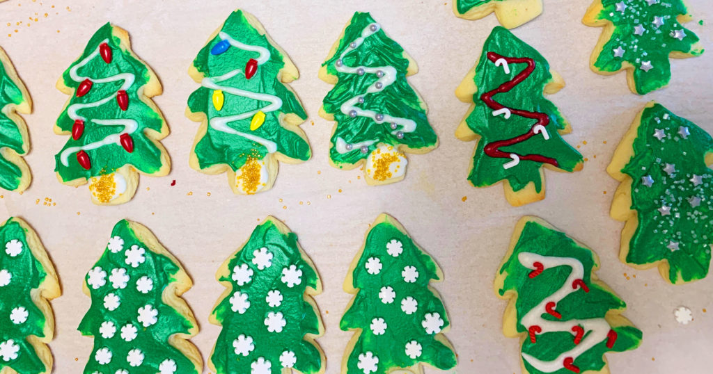 Sheets of hand decorated holiday cookies: adapting a holiday tradition.