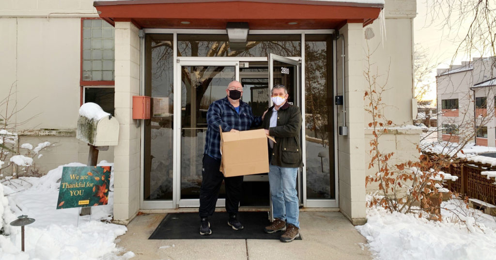 Chuck York, VP Manufacturing delivers individually packaged cookies to R&D Scientists on the Promega Madison Campus, adapting this holiday tradition to the life during a pandemic.