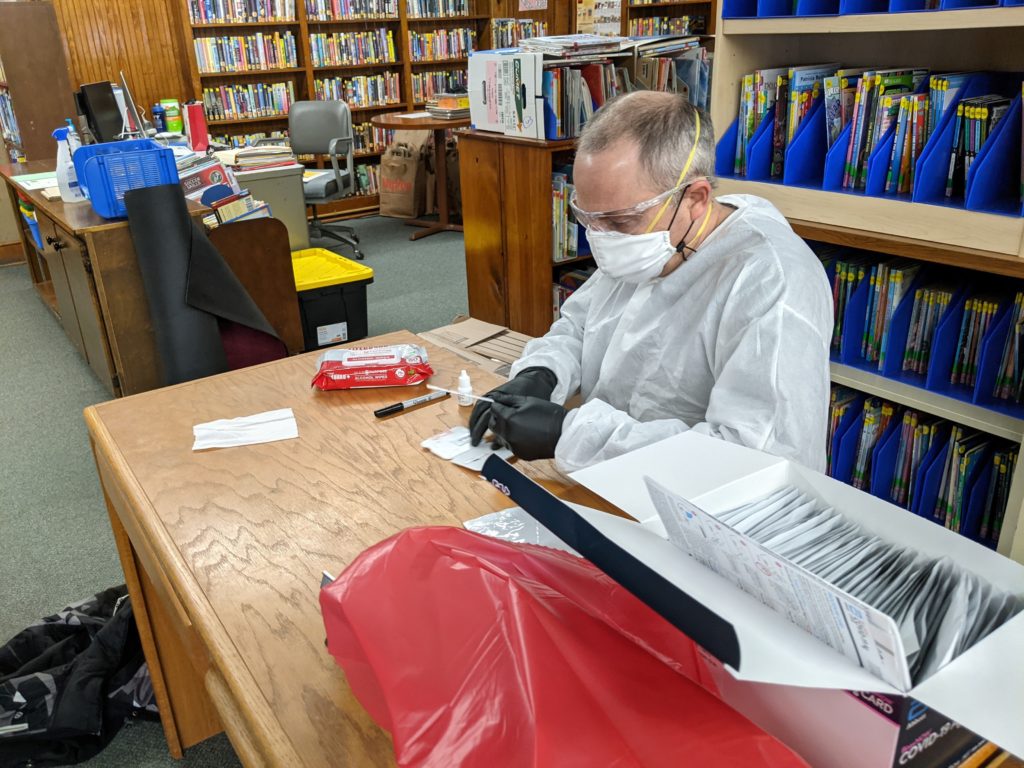 David O'Connor works with an antigen test for COVID-19