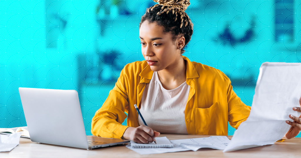 Image: a young woman at a computer. Recent graduates may have transcripts and resumes that look different because of their pandemic experience