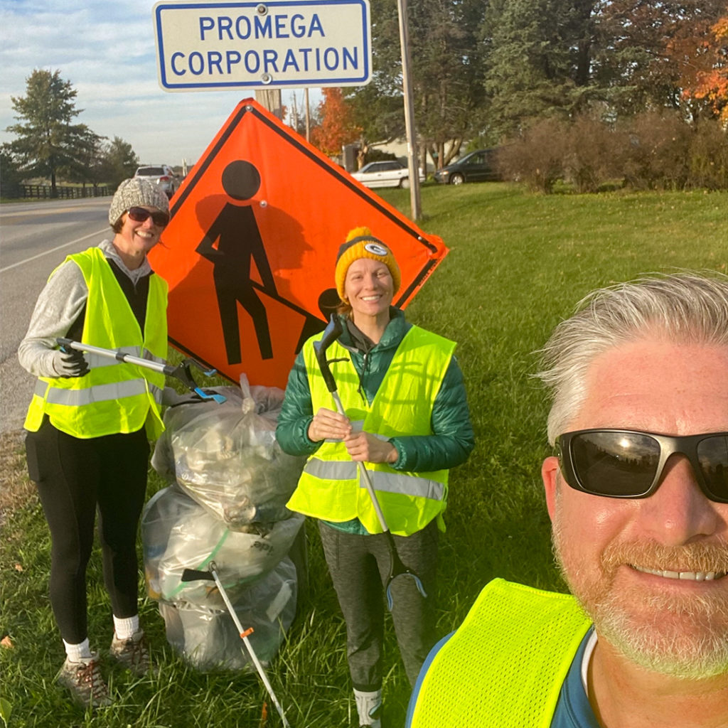 Promega Madison employees volunteering to gather trash from roadside ditches.