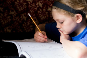 Girl solving math problems. Science writing requires doing some math.