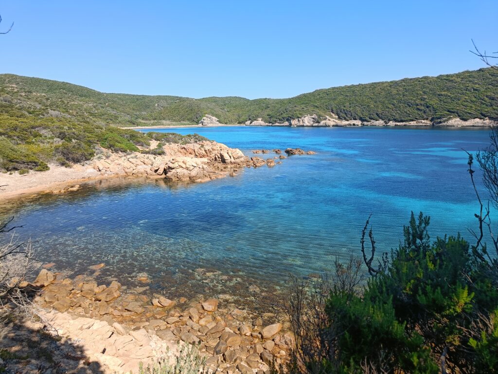 clear blue water surrounded by green hills