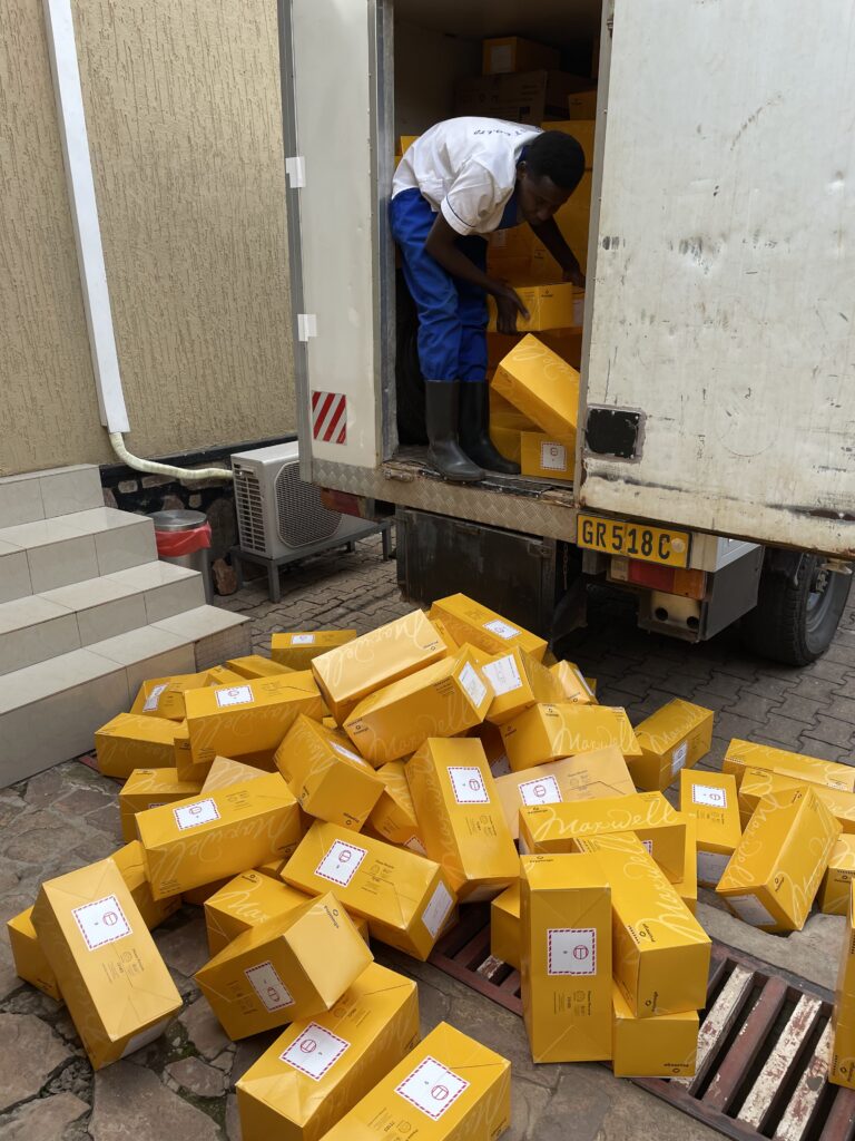 A pile of Maxwell purification kits are unloaded from a truck in Kigali, Rwanda