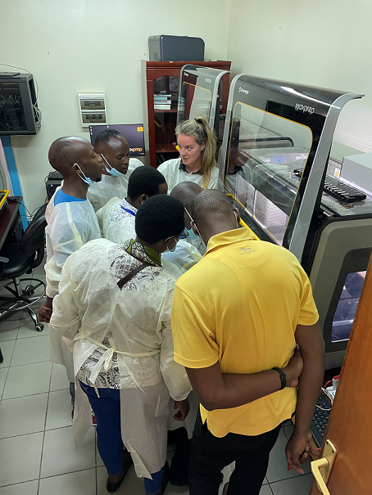 Lucy Swithenbank teaches near the instrument while six trainees listen and learn. 