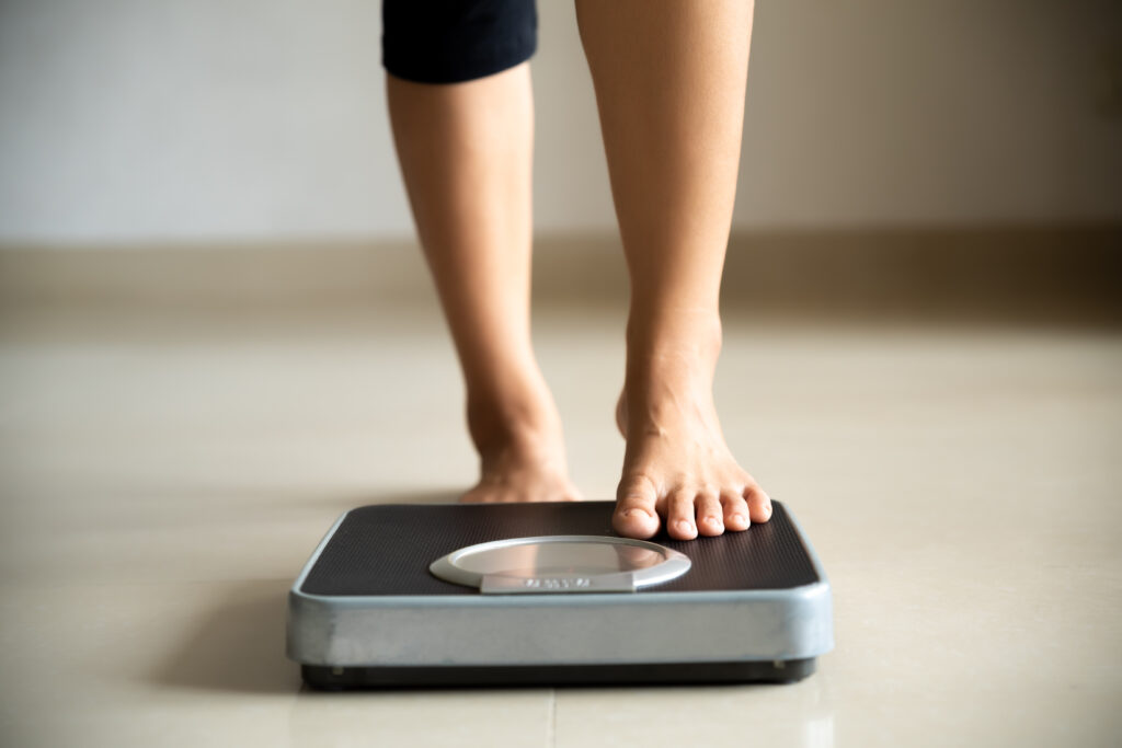 Female leg stepping onto a weigh scale 