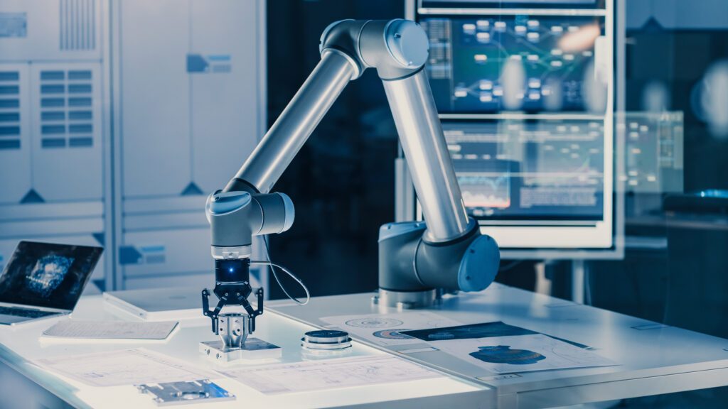 Futuristic Artificial Intelligence Robotic Arm Operates and Moves a Metal Object, Picks It Up and Puts it Down. Scene is Taken in a High Tech Research Laboratory with Modern Equipment.