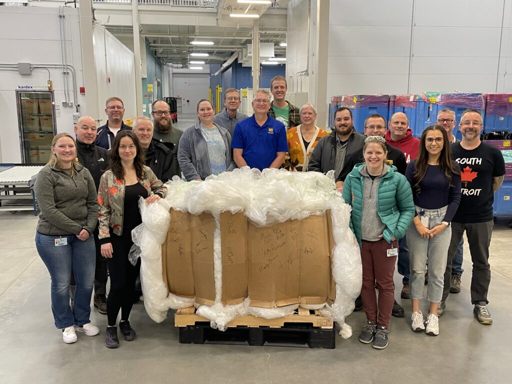 Members of the Sustainability Committee gather at Kepler Center to celebrate the first plastic film bale prepared by the new baler. 