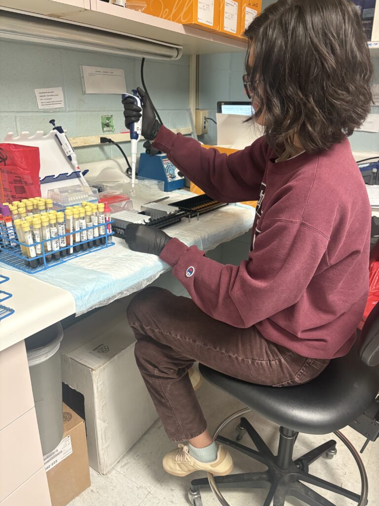 A DCi lab technician adds a sample to a cartridge before loading the Maxwell® instrument.